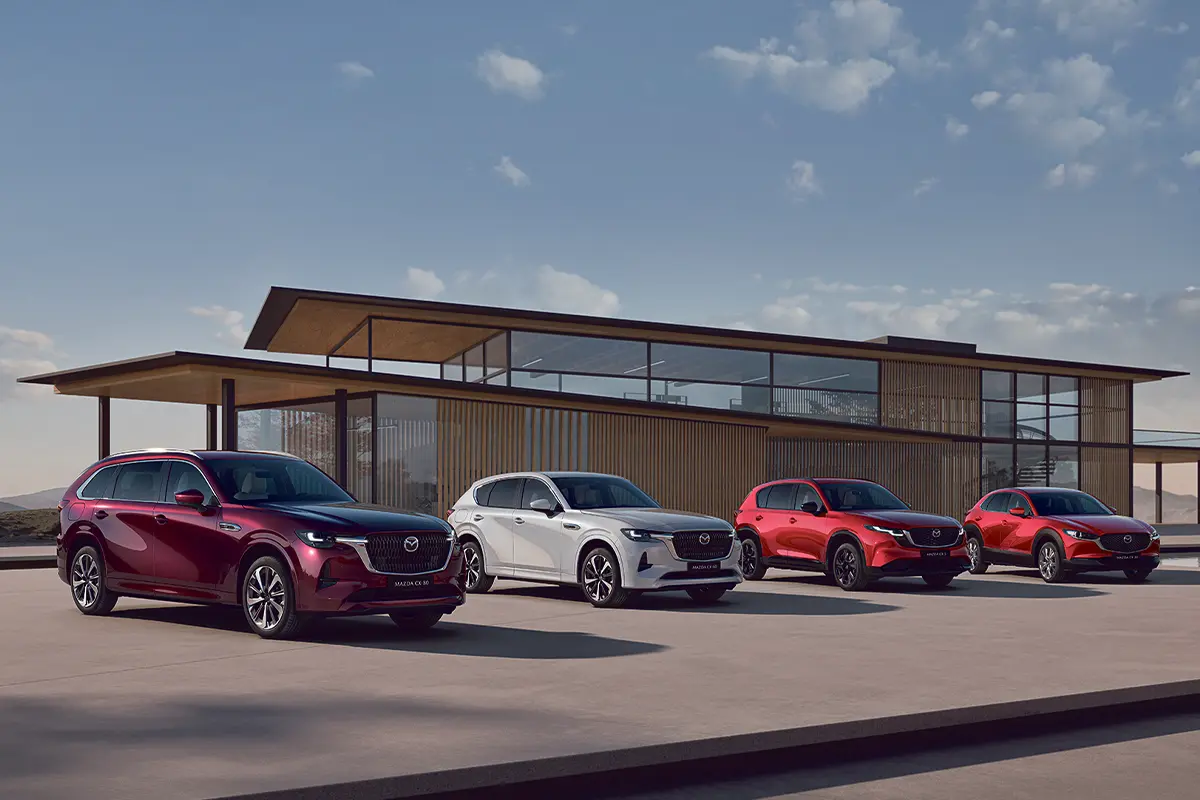 vier Mazda Modelle nebeneinander vor einem Gebäude